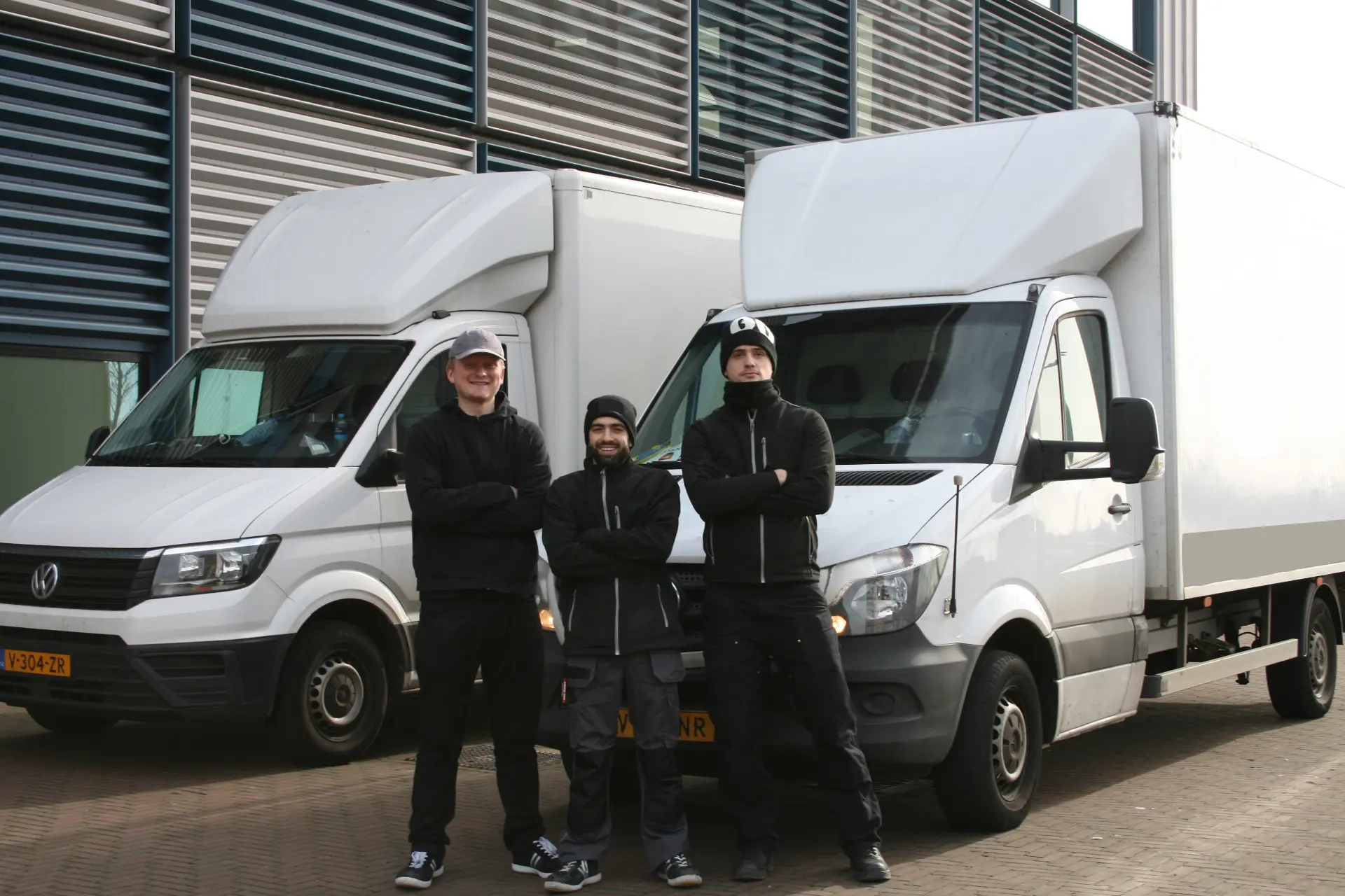 Verhuizers van Monsaro met twee bezorgbusjes op locatie