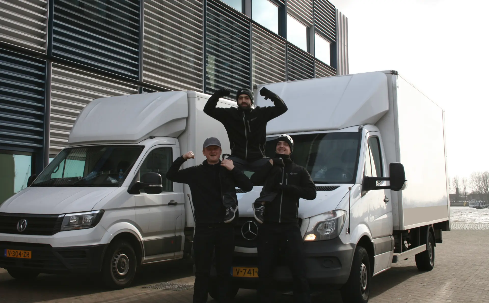 Team van Monsaro in bedrijfskleding tussen twee bezorgbusjes